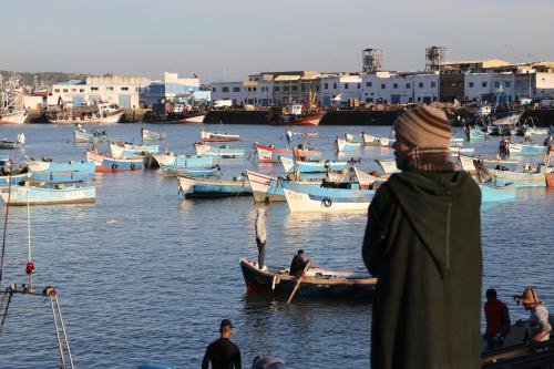a man standing on a dock with boats in the water at Sultana larache in Larache