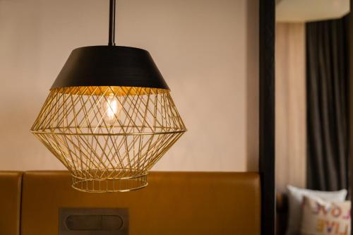 a black and gold lamp hanging over a couch at JEN Singapore Tanglin by Shangri-La in Singapore