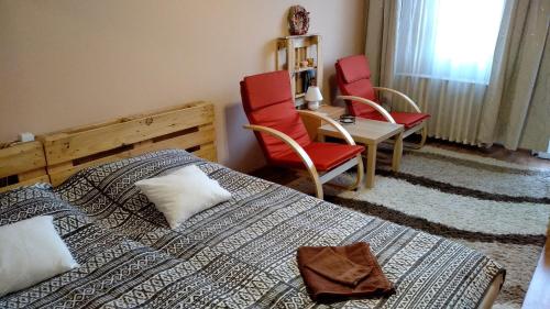 ミシュコルツにあるGesztenyés Apartmanのベッドルーム1室(ベッド2台、椅子、テーブル付)