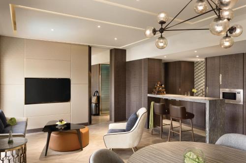 a living room with a tv and a kitchen at JEN Singapore Tanglin by Shangri-La in Singapore