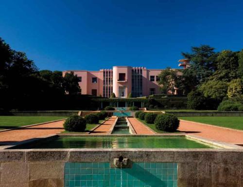 a building with a fountain in the middle of a garden at Oporto Yellow Villas in Porto