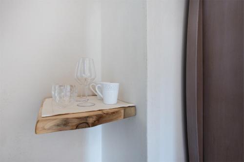 a shelf with cups and a lamp on a wall at Maso Maroni Agriturismo in Quinto di Valpantena