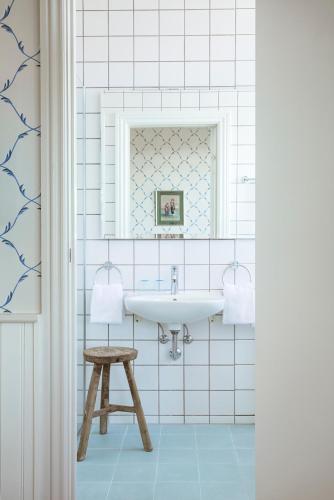 a bathroom with a sink and a stool at Hotel Bretagne in Hornbæk