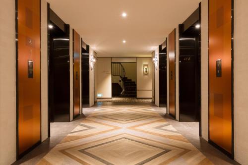 a hallway with wooden floors and black and brown doors at JEN Singapore Tanglin by Shangri-La in Singapore
