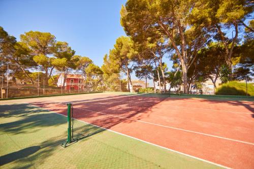 a tennis court with trees in the background at MLL Palma Bay Club Resort in El Arenal