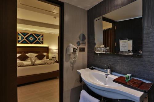 a bathroom with a sink and a bed at Hotel Luminara in Cochin