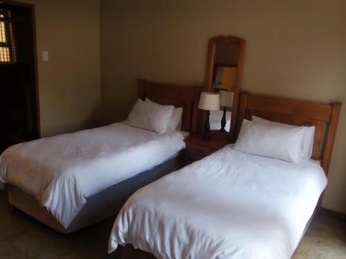 Łóżko lub łóżka w pokoju w obiekcie Woodpecker Guesthouse Middelburg Mpumalanga