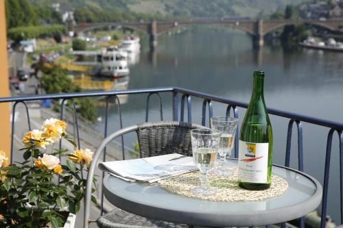 a bottle of wine sitting on a table with glasses at Hotel Karl Noss in Cochem