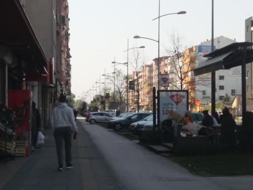 een persoon die over een trottoir in een stad loopt bij Studio Nina in Novi Sad
