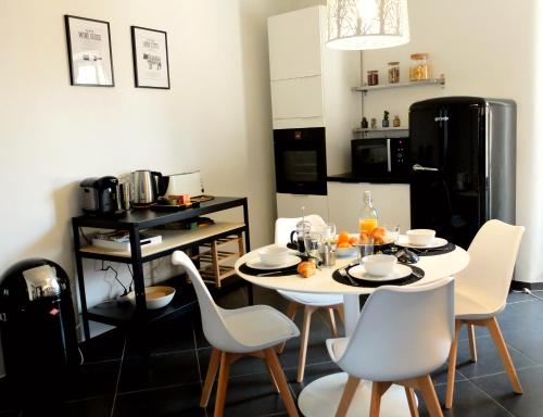 une salle à manger avec une table et des chaises blanches dans l'établissement Chez Thomas, à Colmar