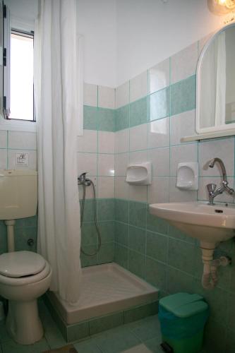 a bathroom with a shower and a toilet and a sink at Kouros Apartments & Studios By Hotelius in Agios Stefanos