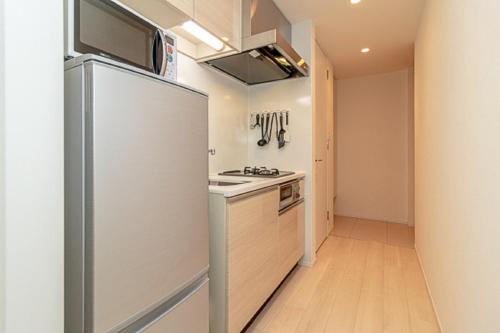 東京にあるOakwood Apartments Minami Azabu Tokyoの冷蔵庫とコンロ付きのキッチン