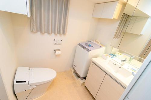 Oakwood Apartments Minami Azabu في طوكيو: حمام صغير مع مرحاض ومغسلة