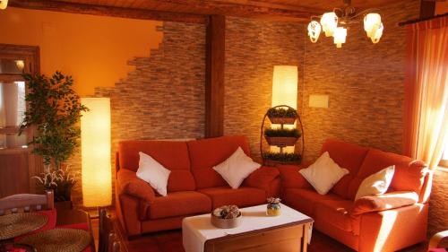 uma sala de estar com um sofá e uma parede de tijolos em La Casa de la Abuela Mari em Trescasas