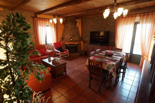 uma sala de estar com uma mesa e uma sala de estar com uma lareira em La Casa de la Abuela Mari em Trescasas