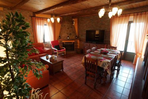 a living room with a table and a living room with a fireplace at La Casa de la Abuela Mari in Trescasas