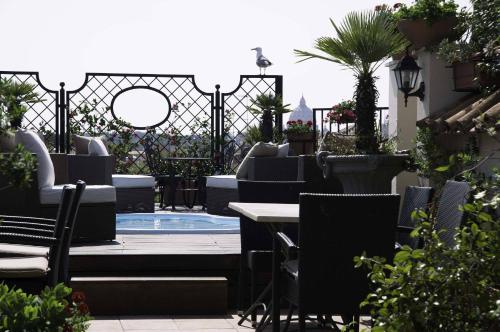 a patio with chairs and a table and a pool at Colonna Palace Hotel in Rome