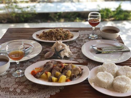 a table with plates of food and glasses of wine at Ancelle Cristo Re in Moalboal