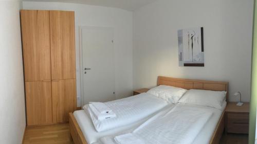 1 dormitorio con 1 cama y armario de madera en Sonnenalpe Apartments Nassfeld en Sonnenalpe Nassfeld
