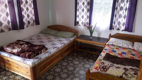 a bedroom with two beds and a window at VAMOOSE SALOM NAMCHEBAZAR in Namchi