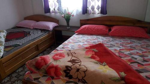 1 dormitorio con 2 camas y una mesa con flores en VAMOOSE SALOM NAMCHEBAZAR, en Namchi