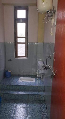 a bathroom with a shower and a window and a sink at VAMOOSE SALOM NAMCHEBAZAR in Namchi
