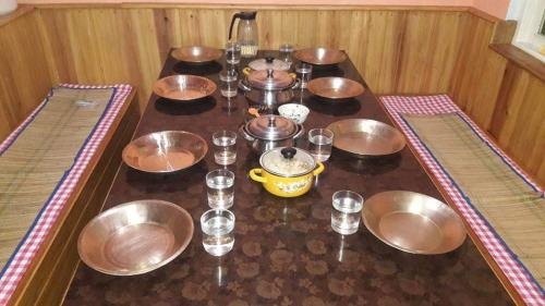 un grupo de tazones y vasos sobre una mesa en VAMOOSE SALOM NAMCHEBAZAR, en Namchi