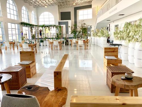 a large room with tables and chairs and plants at ROCCA Del GARDA Residences in Binangonan