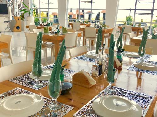 a wooden table with plates and vases with green stems at ROCCA Del GARDA Residences in Binangonan