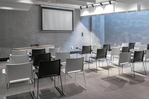 a room with a bunch of chairs and a screen at Vincci Consulado de Bilbao in Bilbao