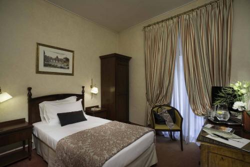 a hotel room with a bed and a window at Colonna Palace Hotel in Rome