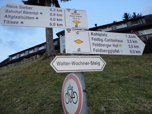 a street sign with several signs on a pole at Hotel Diana in Feldberg