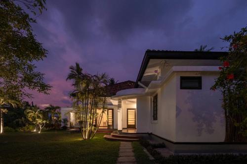a white house at night with the lights on at Abode Ahangama in Ahangama