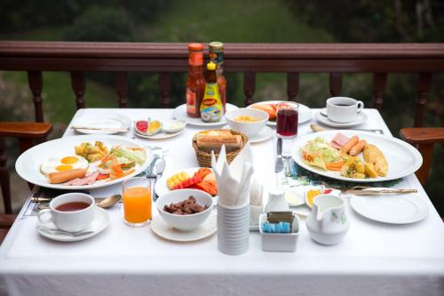 a white table with plates of breakfast food on it at The Imperial Mae Hong Son Resort in Mae Hong Son