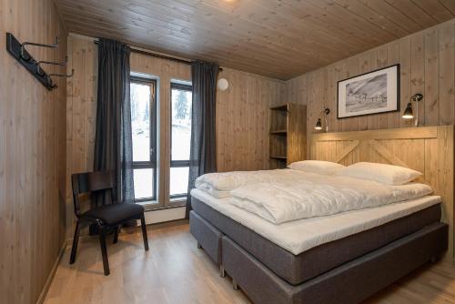 a bedroom with a bed and a chair in it at Varden Fjellandsby Kvitfjell in Kvitfjell