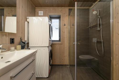 a small bathroom with a refrigerator and a shower at Varden Fjellandsby Kvitfjell in Kvitfjell