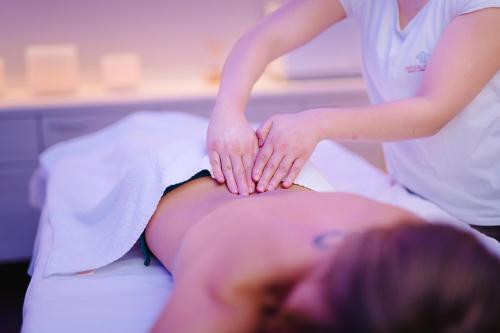 a woman getting a massage on a pregnant woman at Tenuta De L'Annunziata - Natural Relais in Uggiate-Trevano