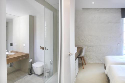 a white bathroom with a toilet and a sink at Quinta Milhão - Casa da Horta in Guimarães