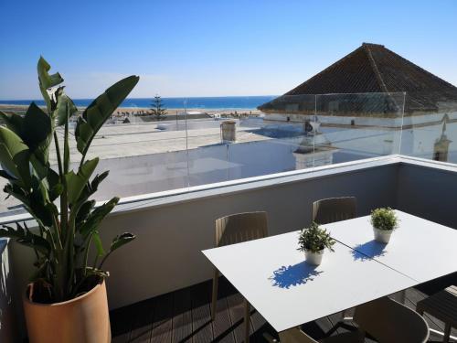 a table and chairs on a balcony with a view of the ocean at Hostal Campito in Conil de la Frontera