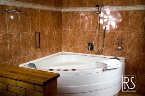a bath tub in a bathroom with a shower at Hotel Azyl in Gorzów Wielkopolski