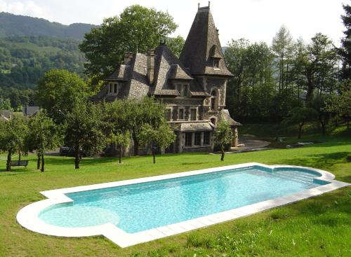an estate with a swimming pool in front of a house at Le Terrondou in Vic-sur-Cère