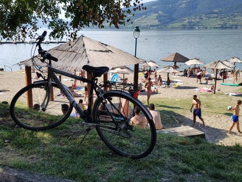 a bike parked next to a beach with people at Nena & Rale Rooms in Donji Milanovac