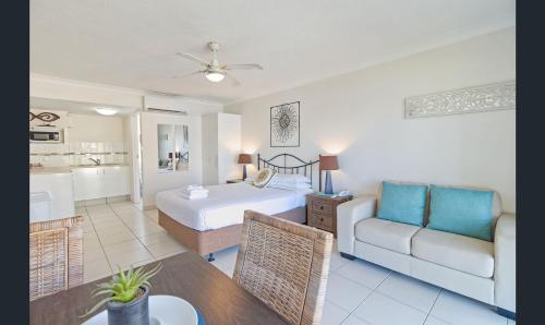 a bedroom with a bed and a couch and a table at Bay of Palms in Gold Coast