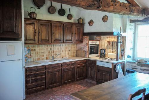 une cuisine avec des armoires en bois et un comptoir dans l'établissement Gîtes de la roblinière, à Landevieille