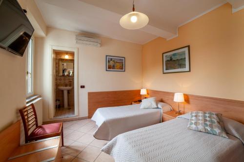 una camera d'albergo con due letti e una televisione di Eliseo B&B Ristorante a Gallicano