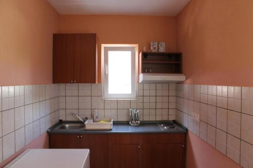 kuchnia ze zlewem i oknem w obiekcie Apartments Isabela w Bašce