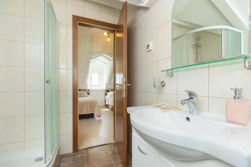 a bathroom with a sink and a mirror and a shower at Hedera Estate, Hedera A19 in Dubrovnik