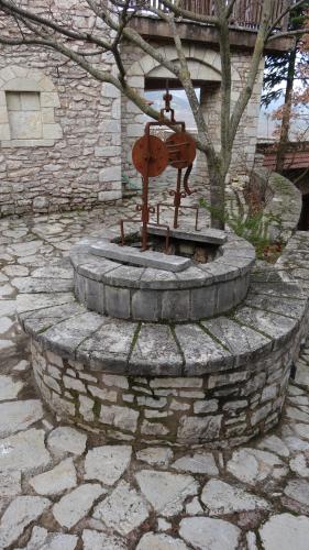 a fountain in a stone circle in front of a tree at Filia House - Kalavryta in Klitoria