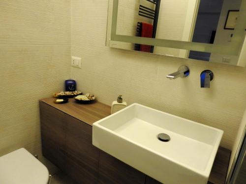 La salle de bains est pourvue d'un lavabo blanc et de toilettes. dans l'établissement Seventy, à Sperlonga