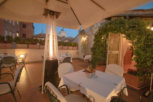 an outdoor patio with tables and chairs and an umbrella at Hosianum Palace in Rome